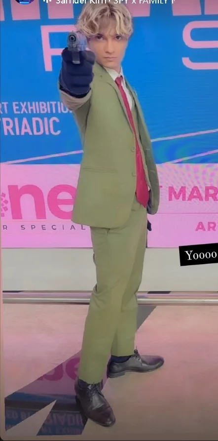 Full-body green-suit cosplay portrait holding a prop toward the camera