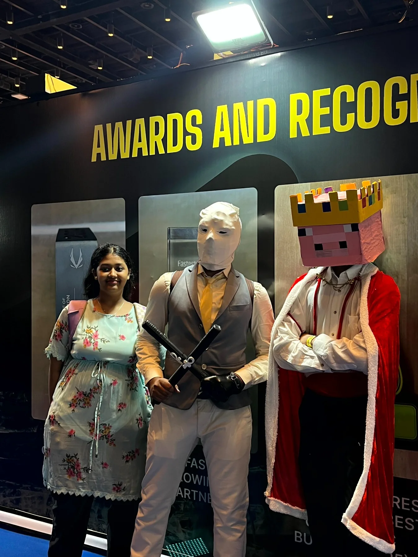 Pig-king cosplay posing beside other attendees at an awards display
