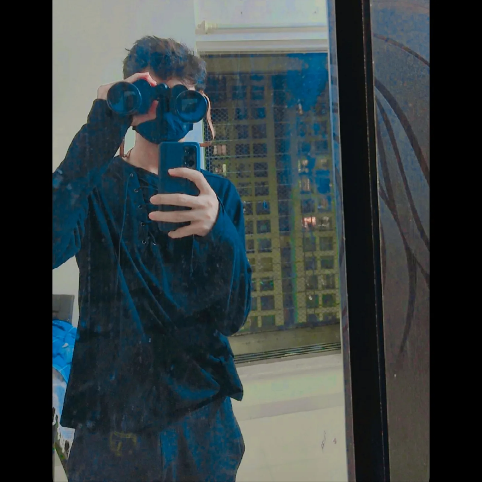 Mirror portrait holding binoculars